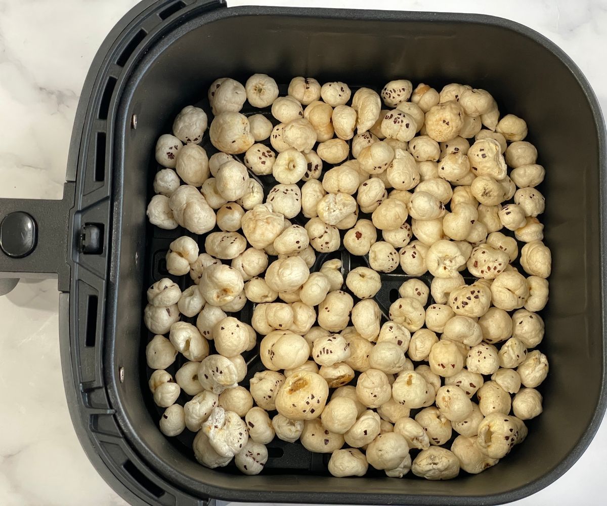 Air fryer basket is filled with lotus seeds.