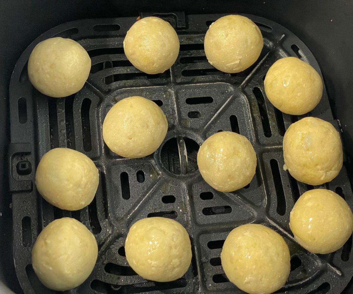 Air fryer basket has vegan malai kofta balls.