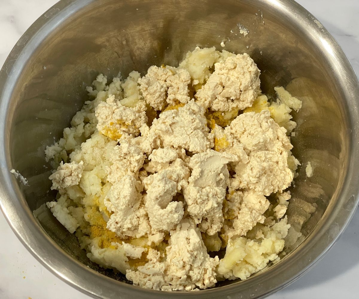 A bowl has mashed potatoes and tofu paste.