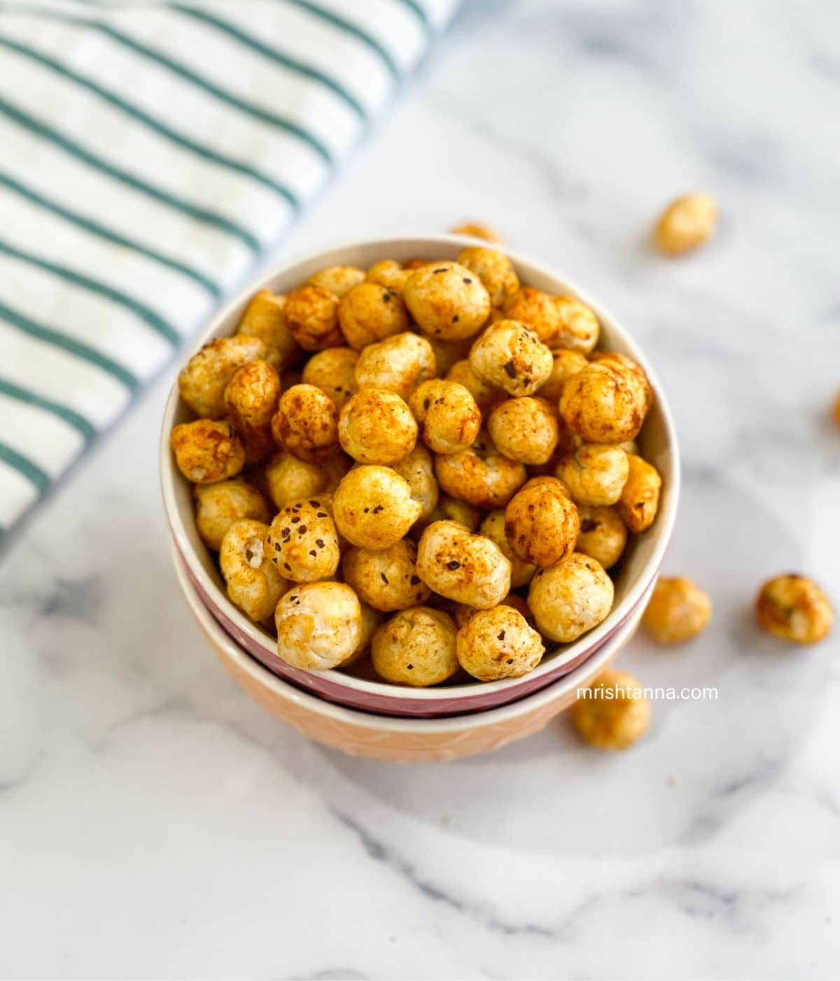 A bowl of roasted lotus seeds is on the table.