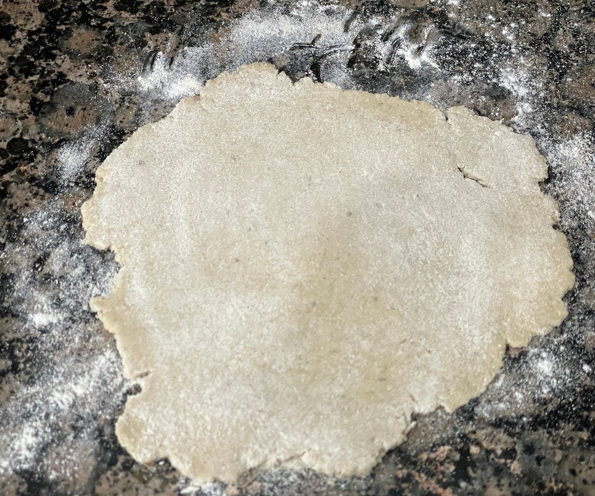 A flattened dough is on the counter top.