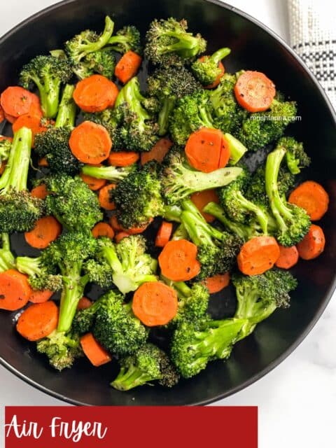 A plate is full of air fried carrots and broccoli.