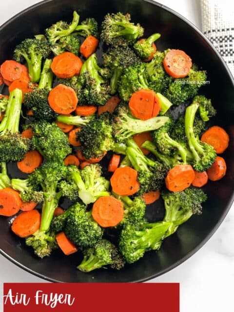 A plate is full of air fried carrots and broccoli.
