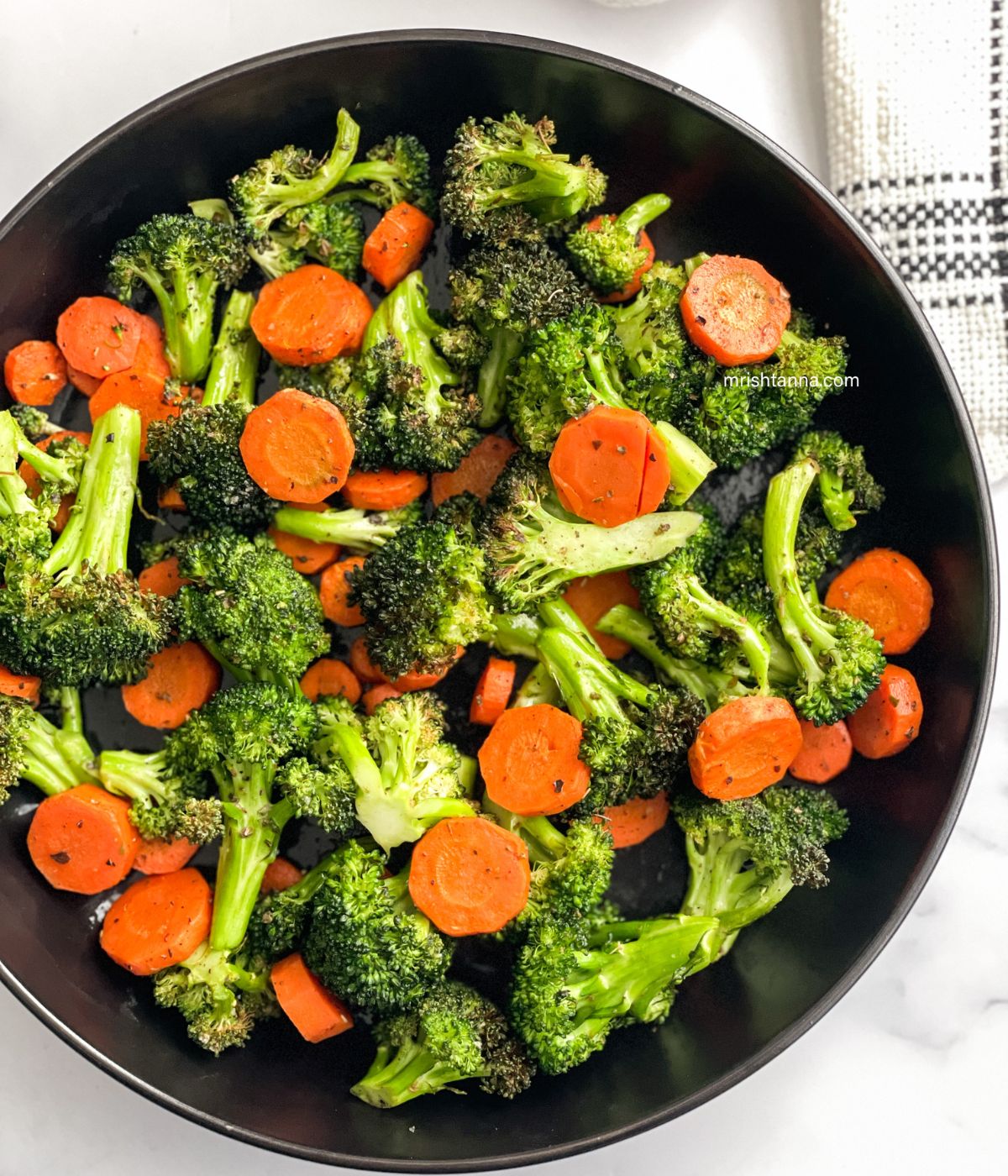 A plate is full of roasted carrots and broccoli.