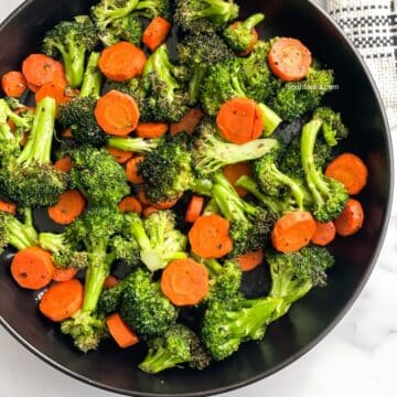 A plate is full of roasted carrots and broccoli.