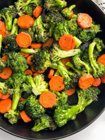 A plate is full of roasted carrots and broccoli.