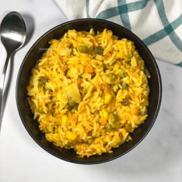 A bowl of Bengali moong dal khichdi is on the surface.