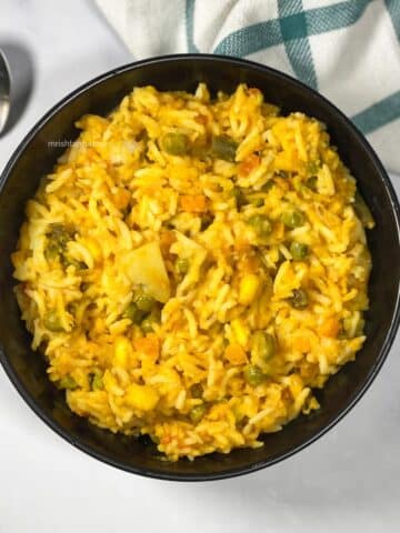 A bowl of Bengali moong dal khichdi is on the surface.