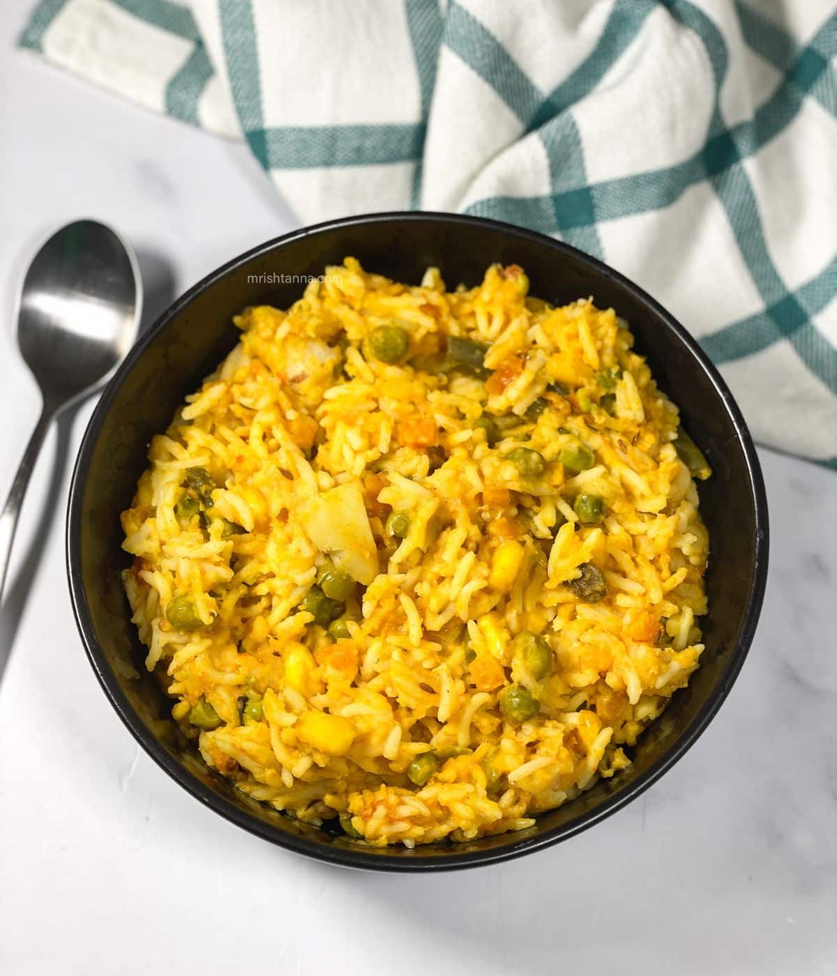 A bowl of Bengali khichdi is on the table.