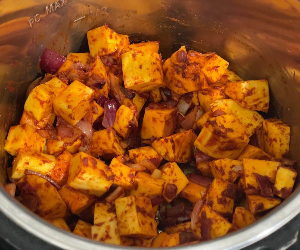 An instant pot has butternut squashes and spices.