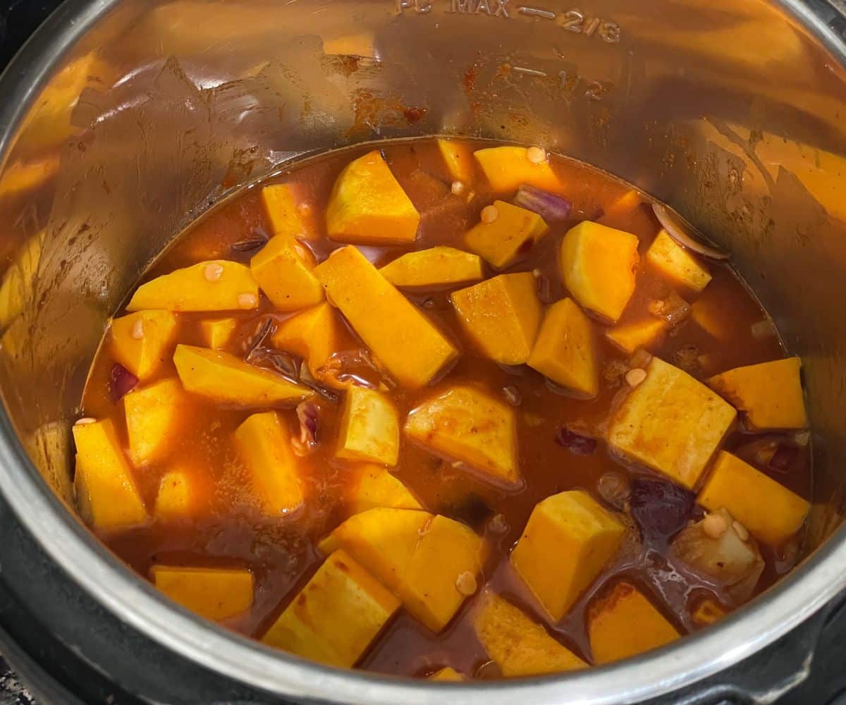 An instant pot filled with butternut squash curry ingredients.