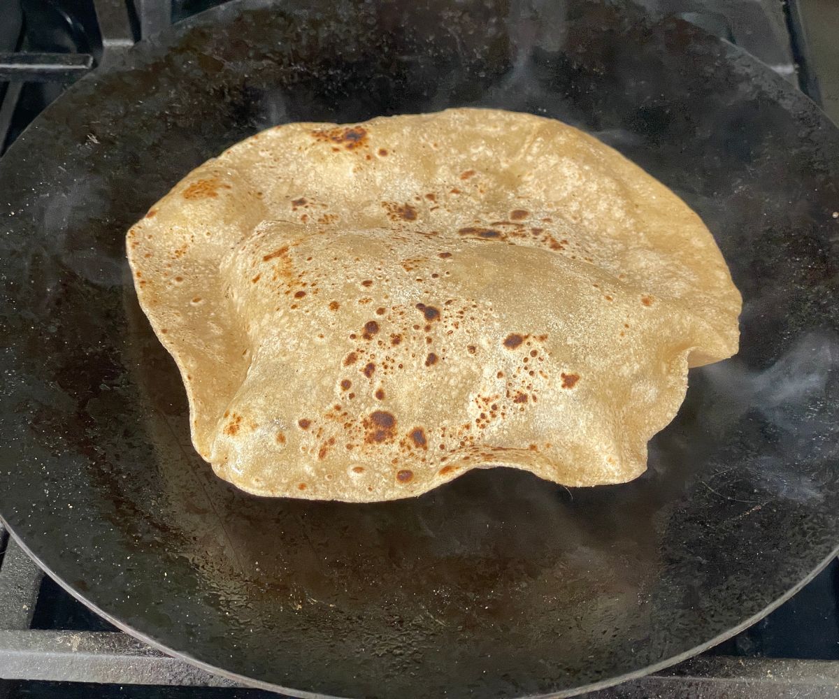 A tawa has a cooked soft chapati.