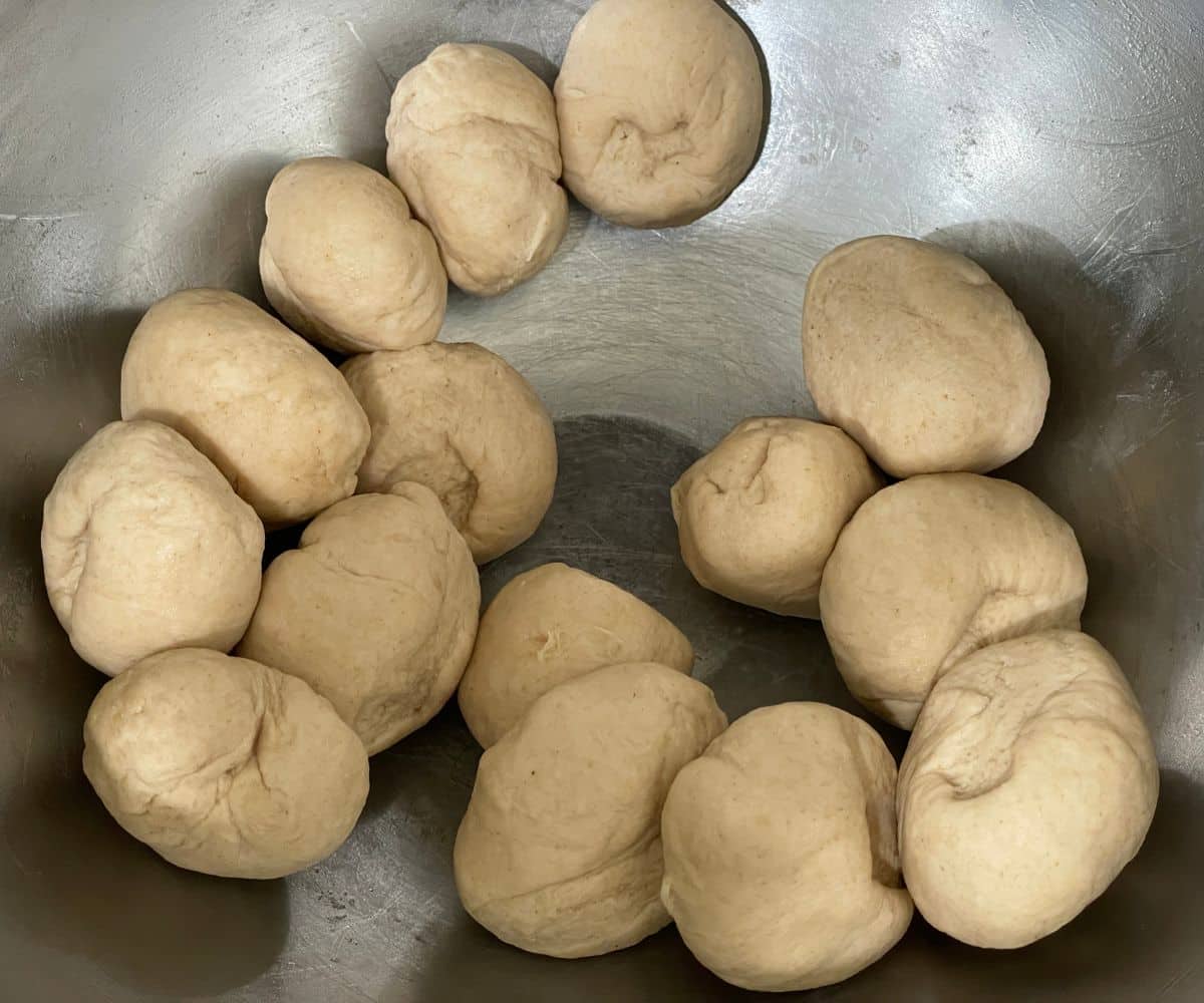 A bowl is with small round chapati dough balls.