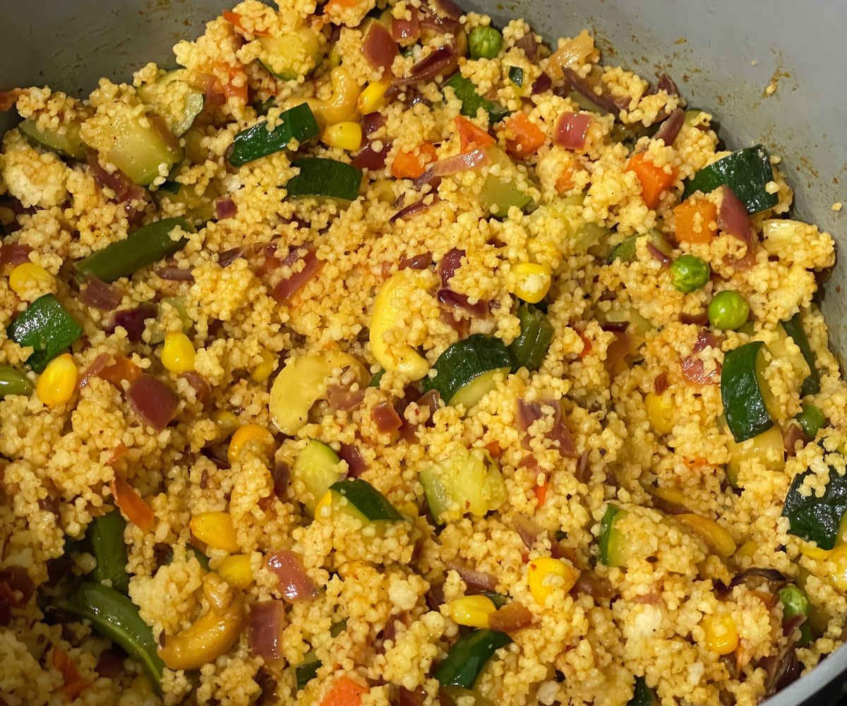 A pot has curried couscous on medium heat.