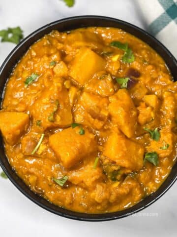 A bowl of butternut squash curry is on the table.