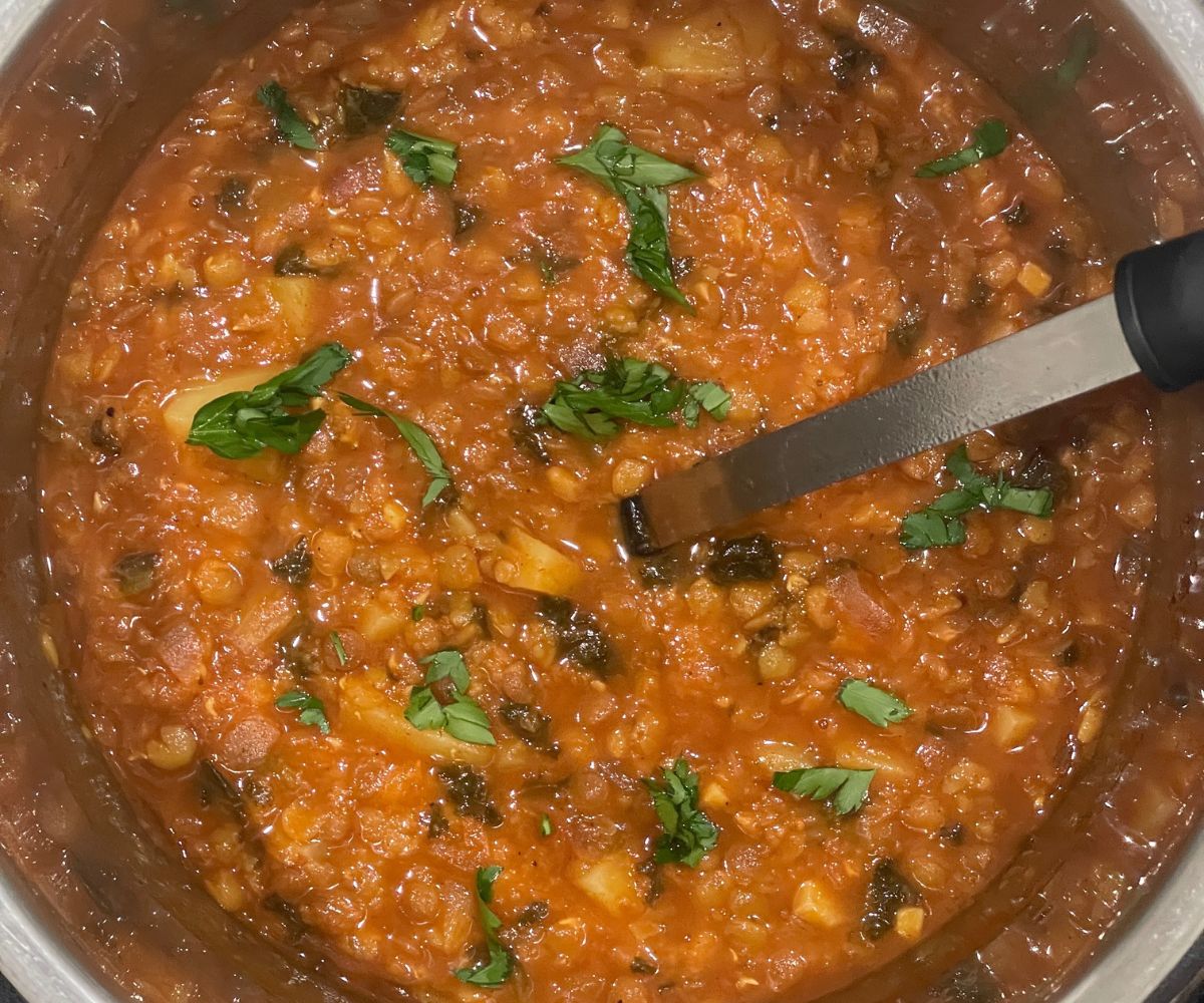 An instant pot is full of vegan lentil soup.