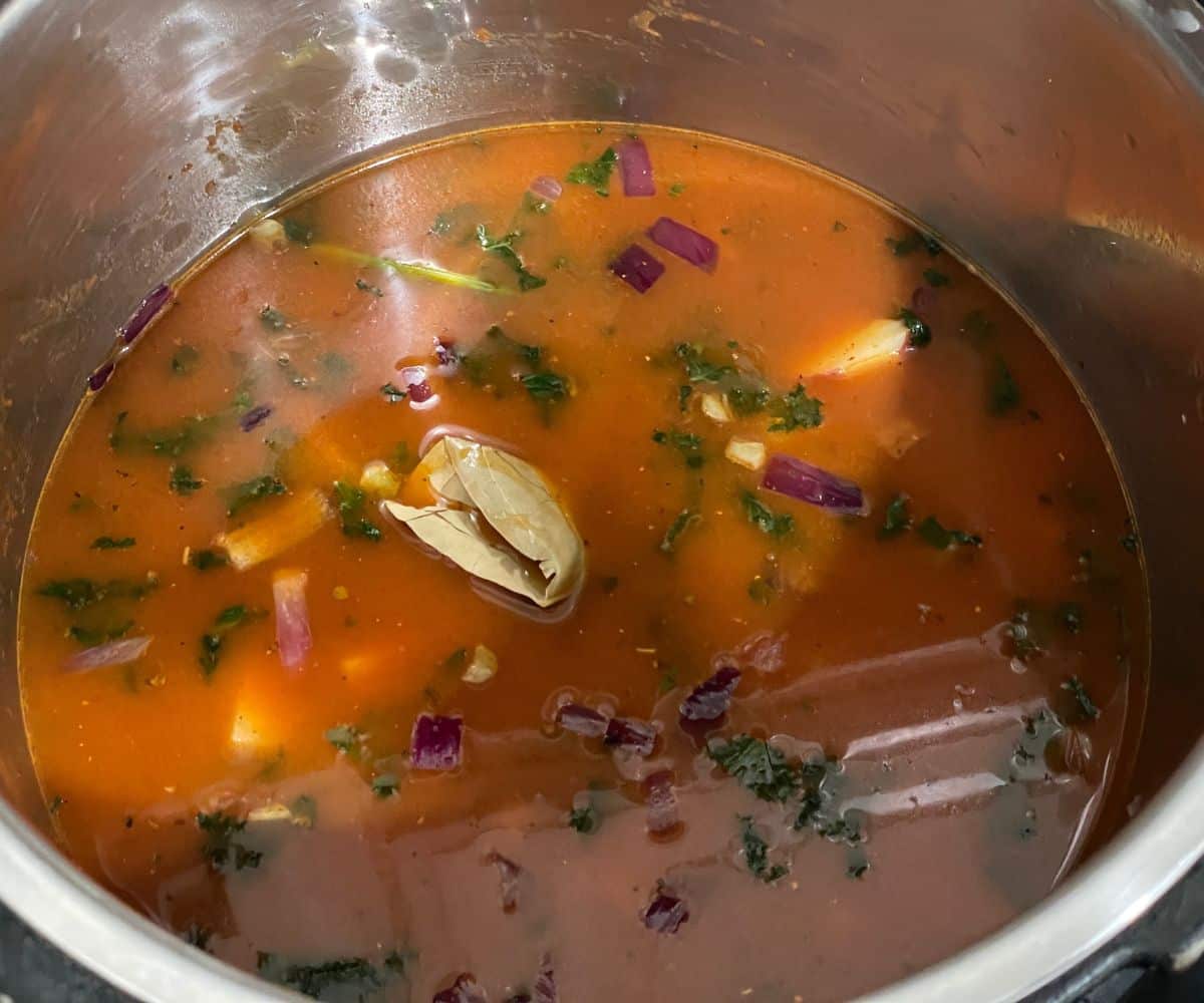 A pot has full of vegan lentil soup mixture.