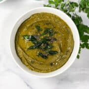 A bowl has drumstick leaves chutney.