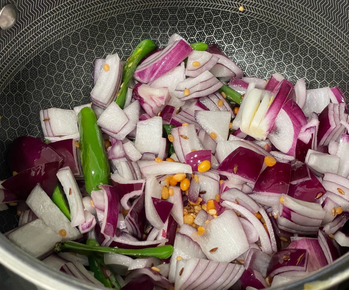 A pot has spices and onions for chutney.