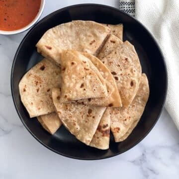 A plate of soft chapati sitting on a table.