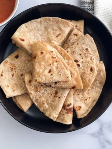 A plate of soft chapati sitting on a table.