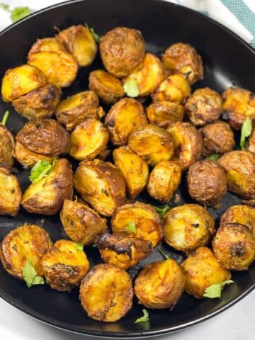 A plate has air fryer Tandoori Potatoes.