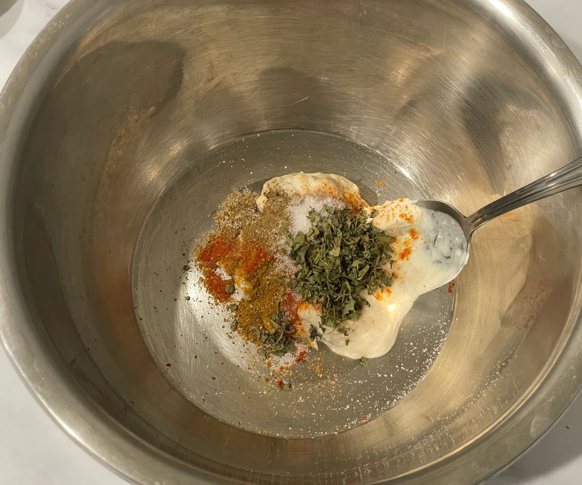 A bowl is with spices and yogurt for marinade.