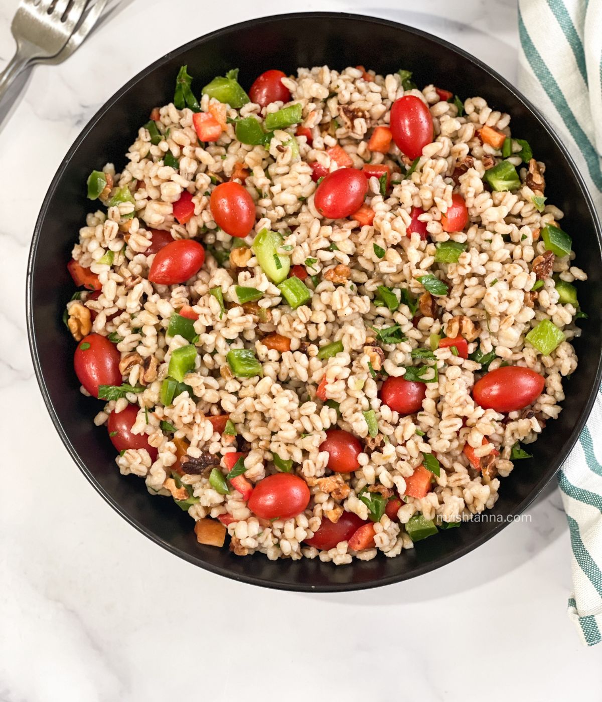 A plate of vegan barley salad is on the table.