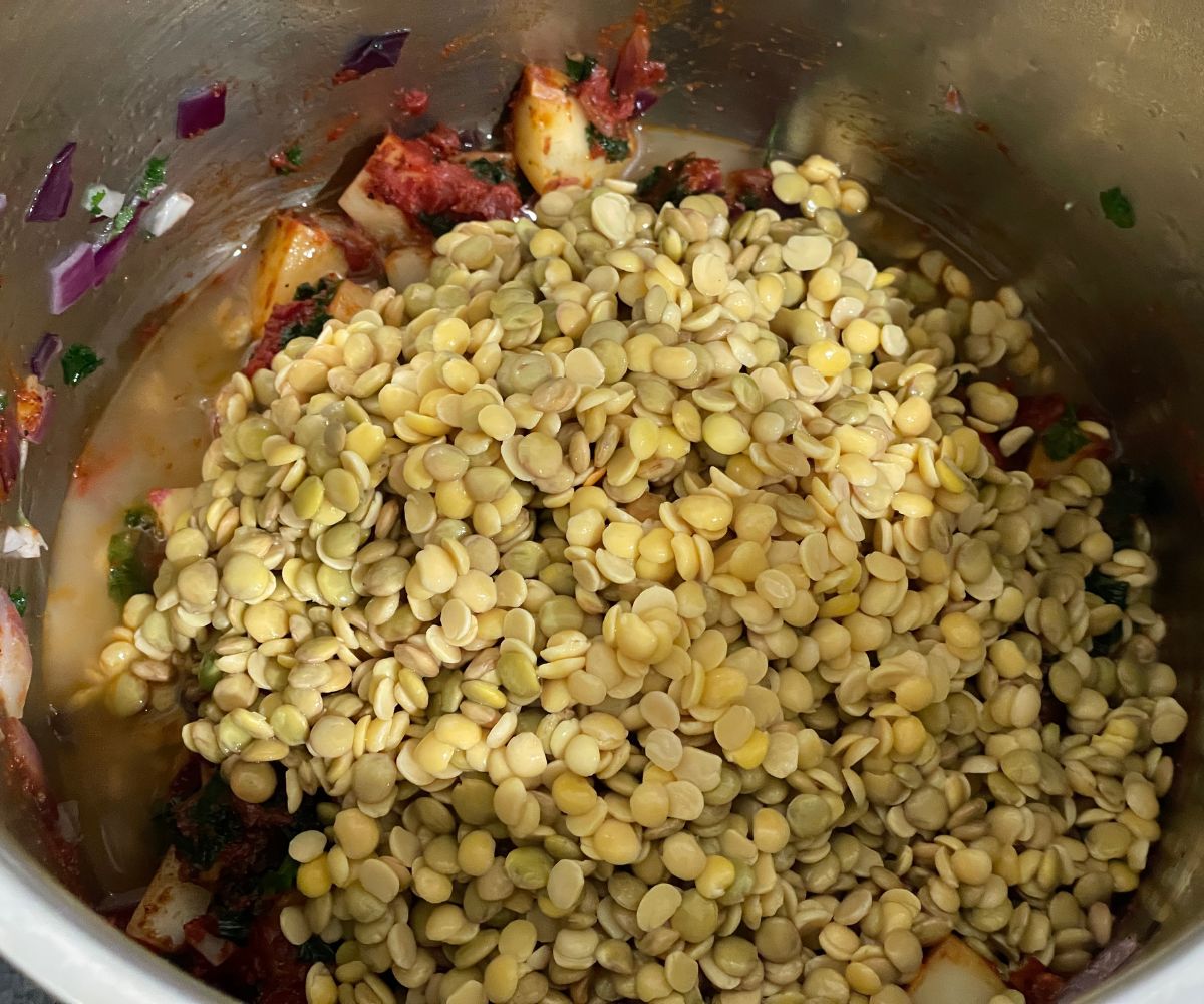 An instant pot is with lentil soup mixture.