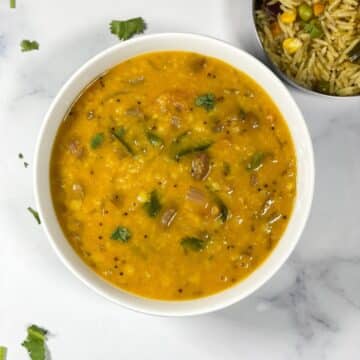 A bowl of Gujarati dal is on the surface.