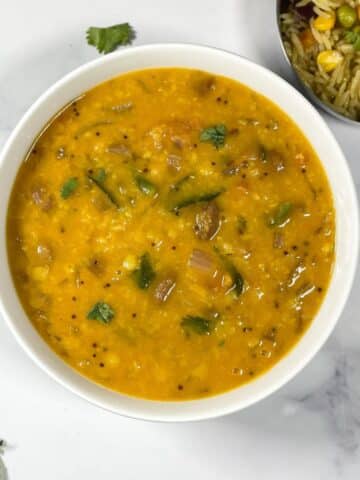 A bowl of Gujarati dal is on the surface.