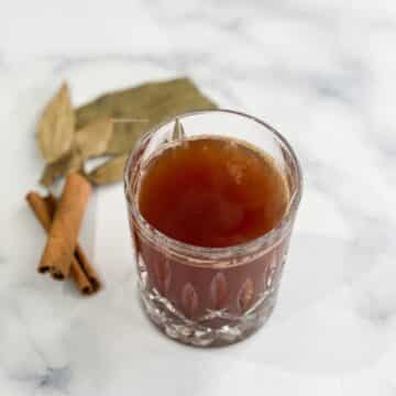 A glass bowl has bay leaf cinnamon tea.