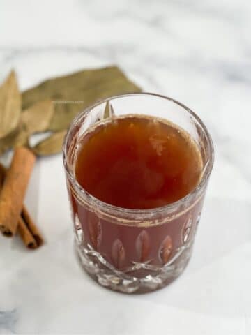A glass bowl has bay leaf cinnamon tea.