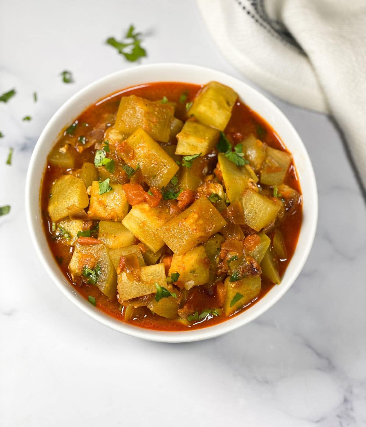 A bowl has lauki sabzi and is placed on the table.