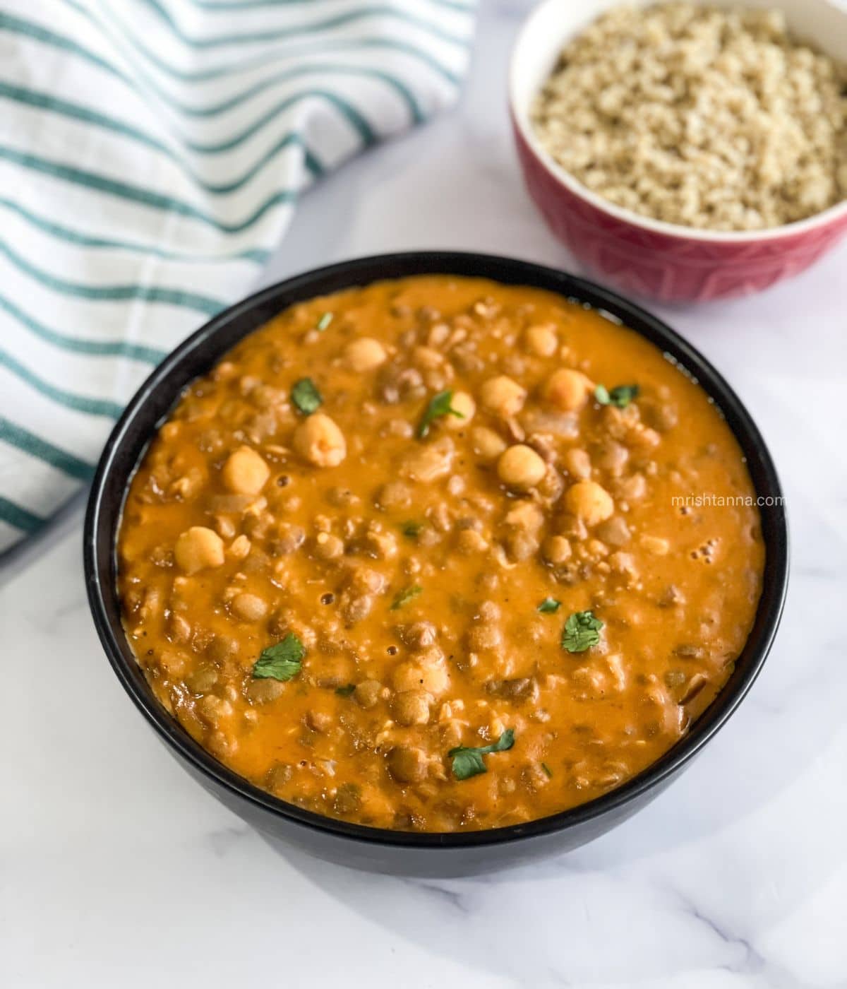 A bowl has Chickpea and lentil curry.