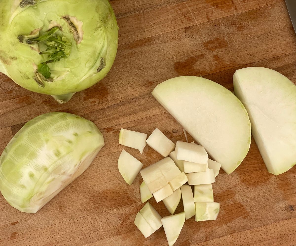 Wooden board has kohlrabi  cubes.