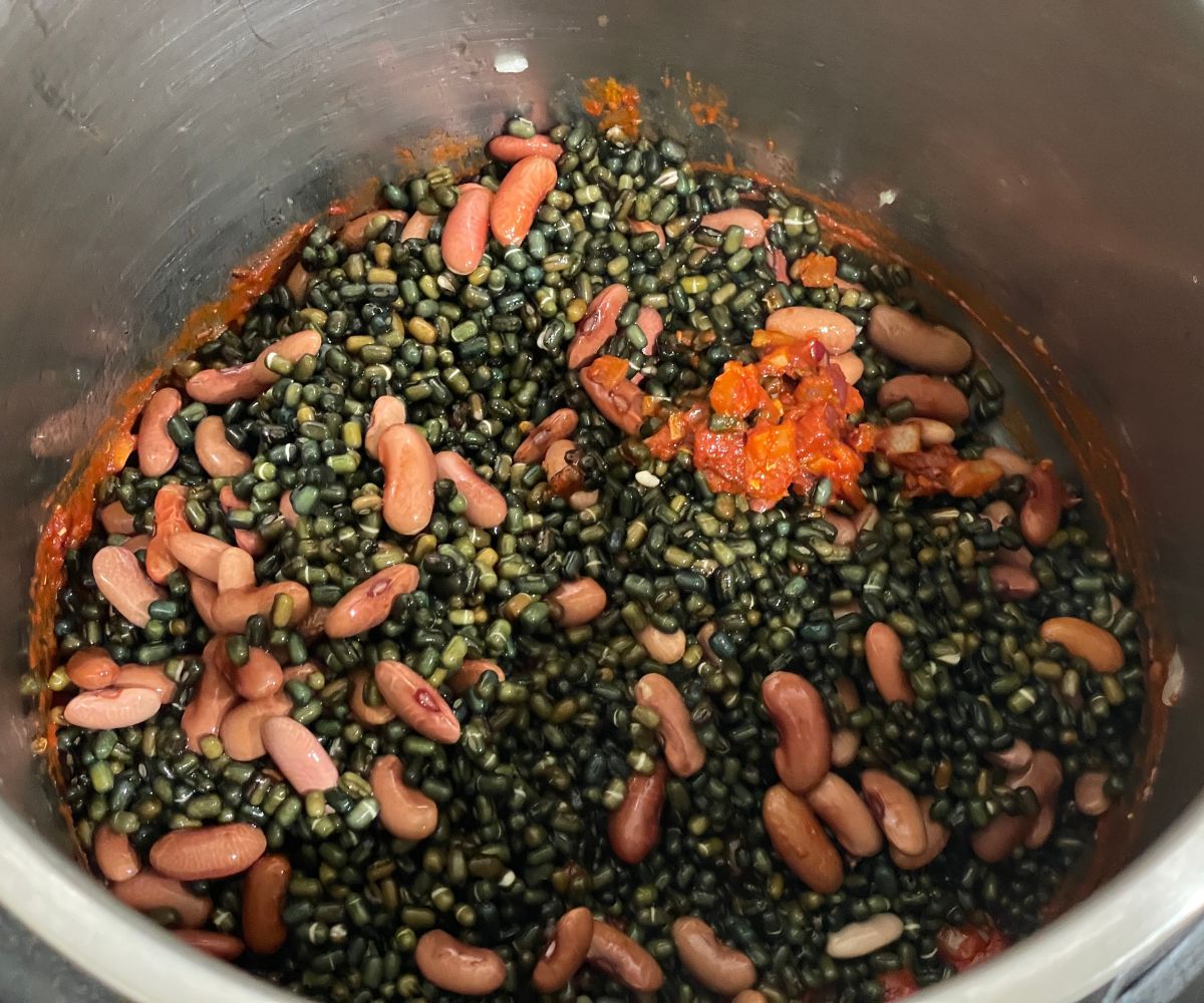 An instant pot has soaked lentils and spices.