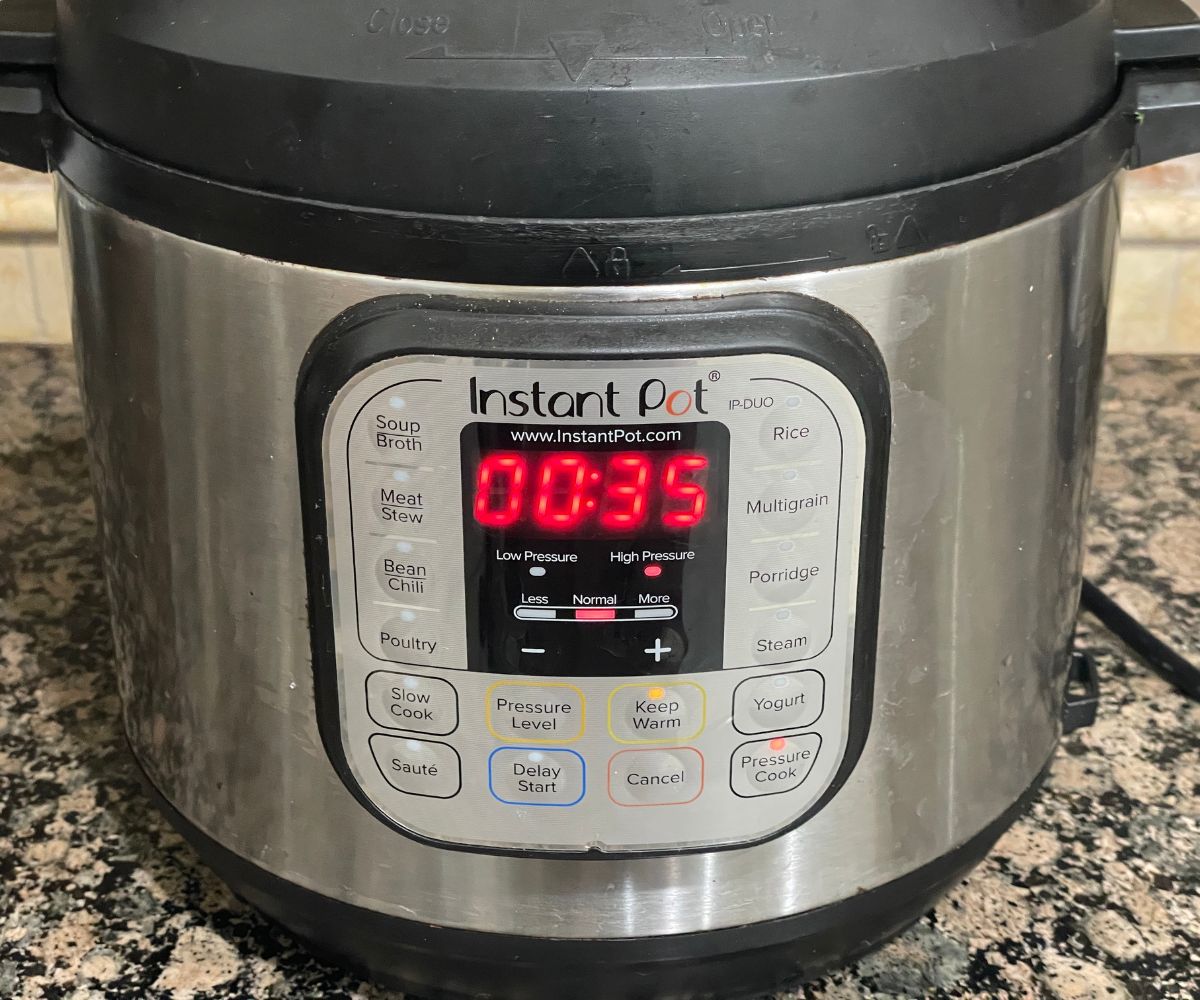 Instant pot is on the counter top showing cooking time.