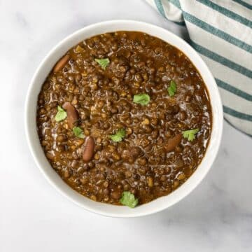 A bowl of vegan Dal Makhani curry is on the surface.