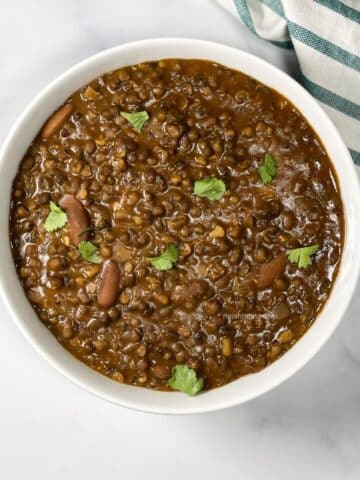 A bowl of vegan Dal Makhani curry is on the surface.