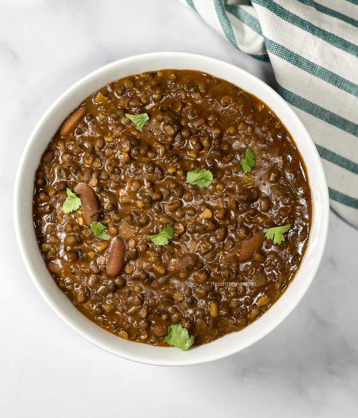 A bowl of vegan dal makhani is on the table.