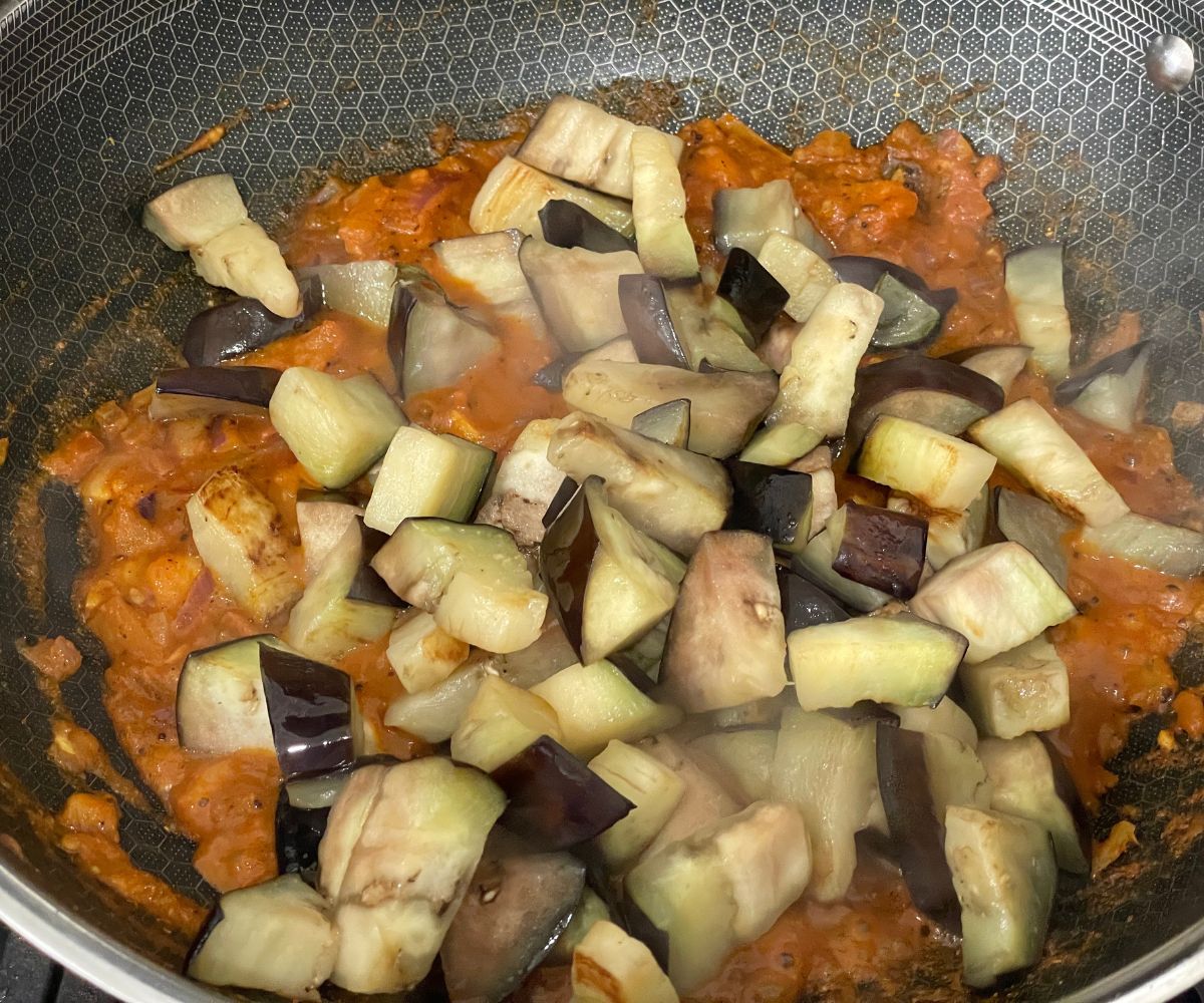 A pan is with roasted eggplant and masalas.