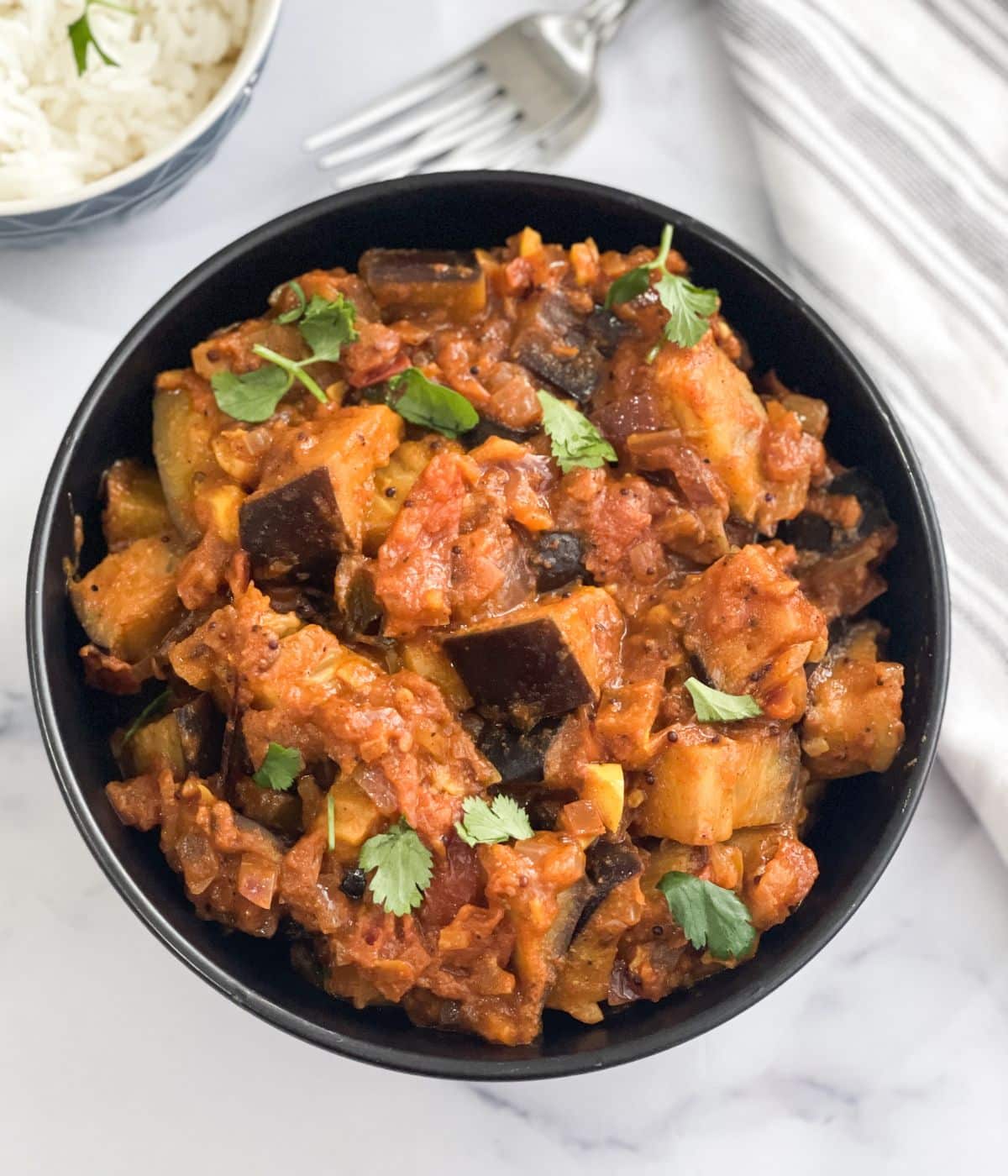 A bowl is full of eggplant masala.