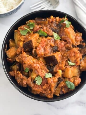 A bowl is full of Indian Eggplant masala curry.