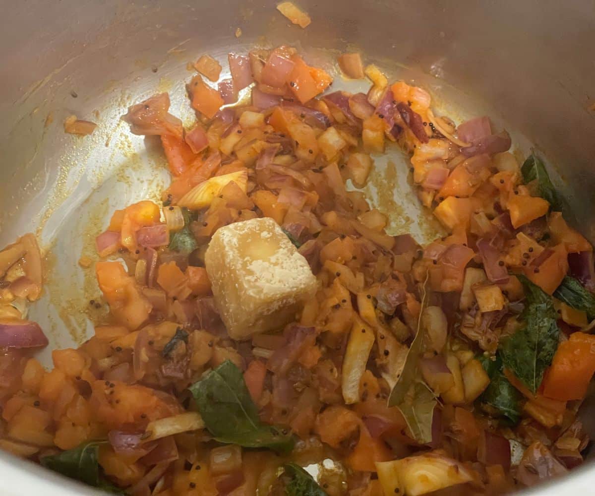 An instant pot has gujarati dal ingredients on saute mode.