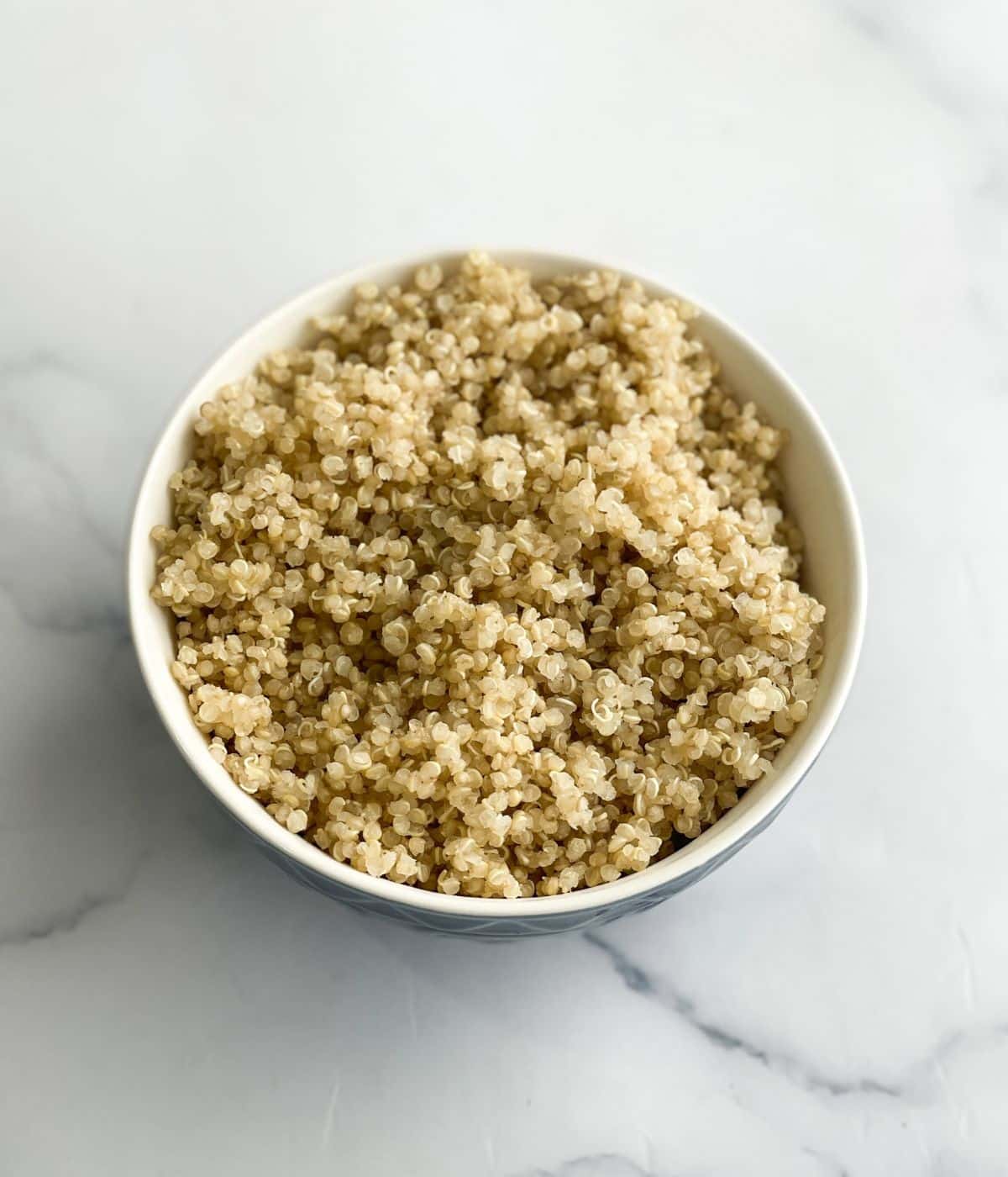 A bowl of quinoa is on the surface.