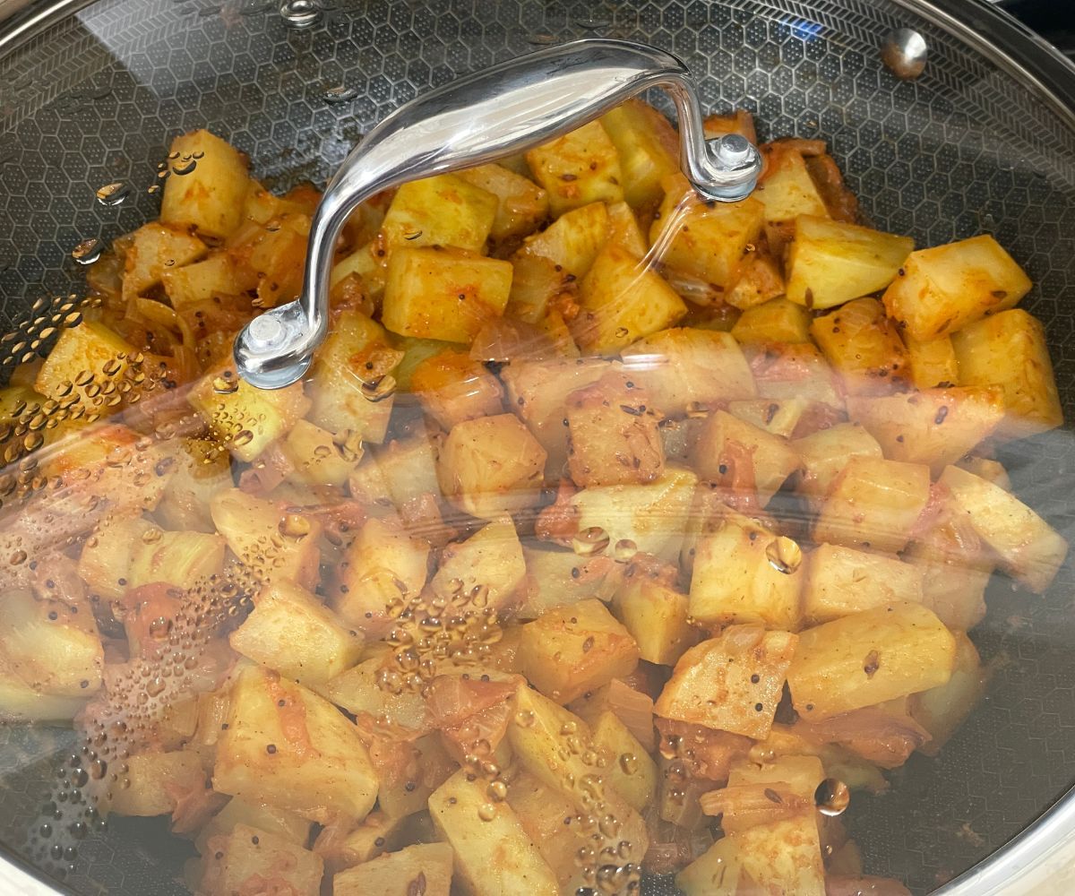 A pan is with Indian kohlrabi curry and lid closed.