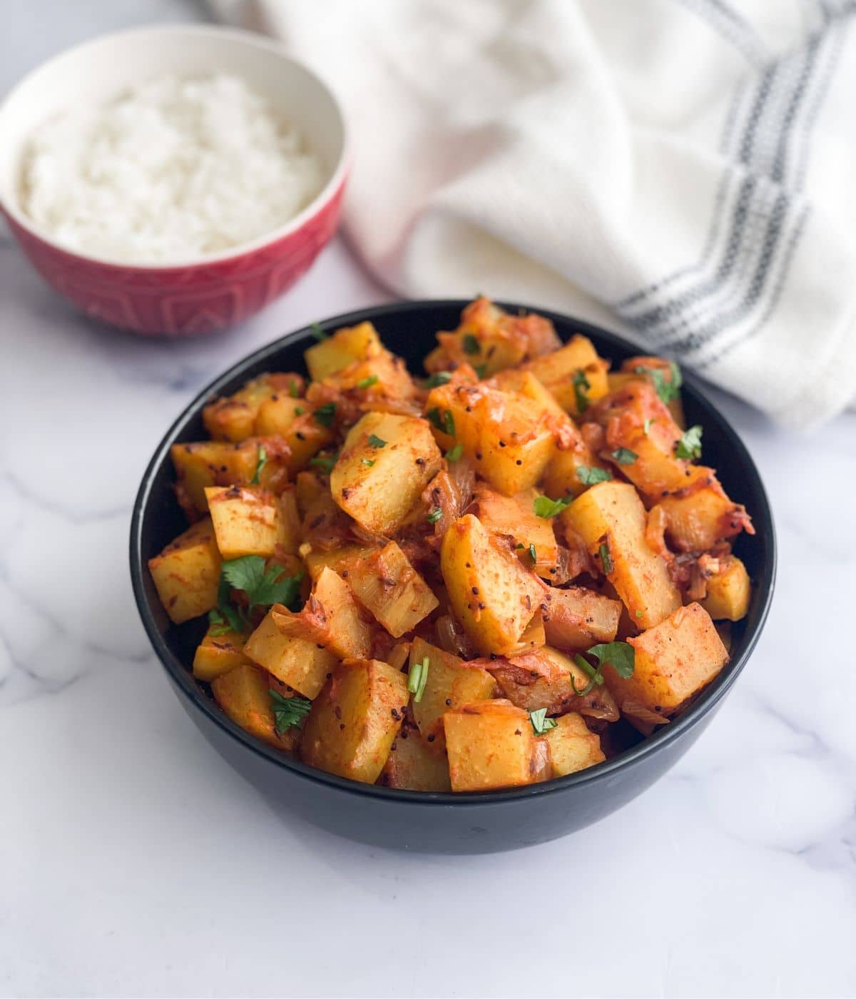 A bowl has kohlrabi curry on the surface.