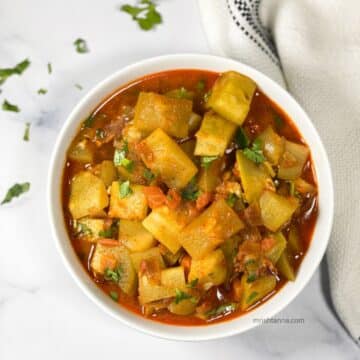 A bowl of Instant pot bottle gourd curry is on the table.