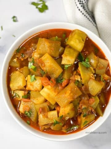 A bowl of Instant pot bottle gourd curry is on the table.